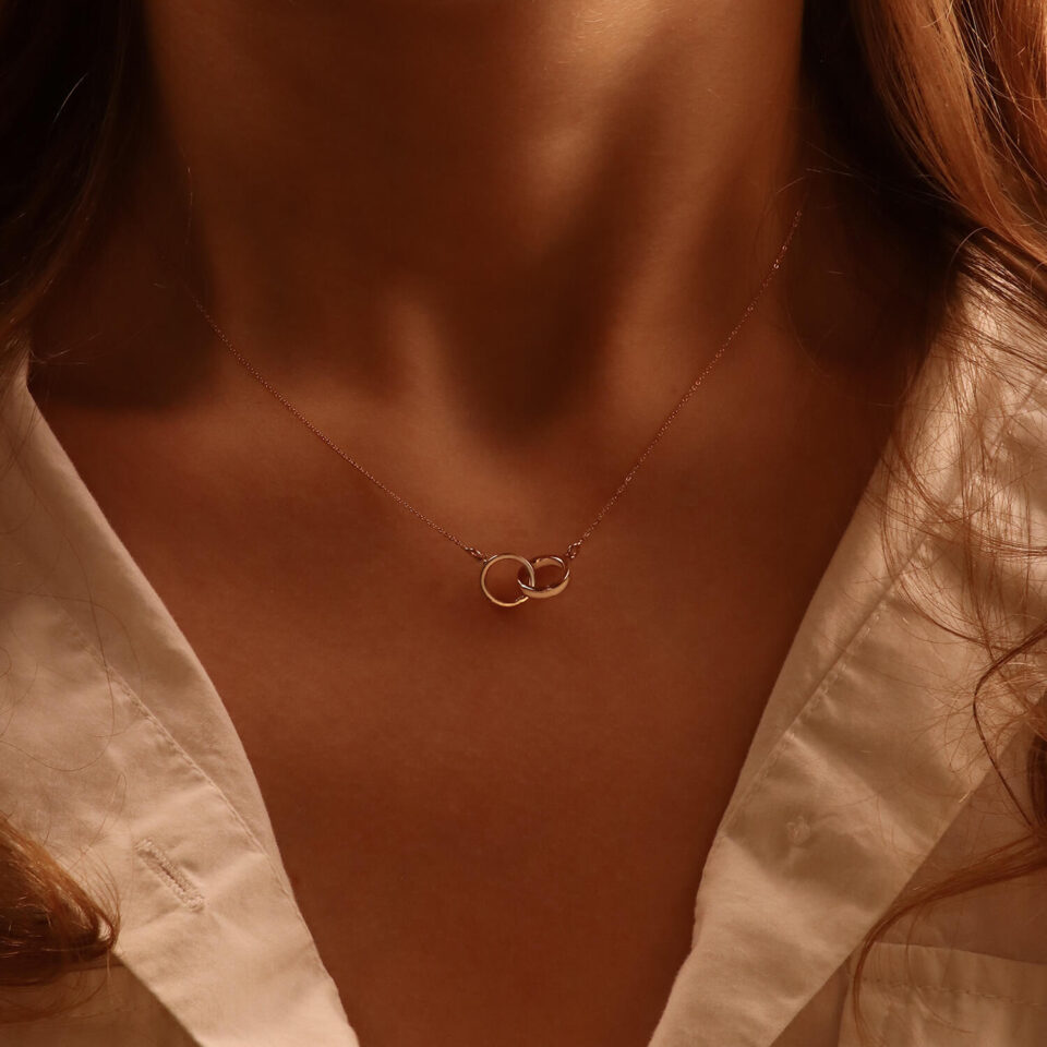 Kullakett ripatsiga "Kaks sõrmust" kaelas