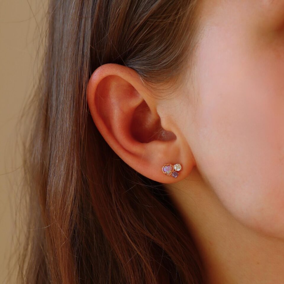 Złote kolczyki "Serce z opalem" w uchu